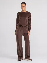 Pantalón de corte recto confeccionado en tejido plush con acabado aterciopelado. Presenta cintura elástica, bolsillos laterales y un bolsillo trasero, ofreciendo una caída fluida y cómoda.