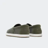 Alpargata sin cordones color verde militar, con capellada de lona de algodón reciclado y talón de gamuza. Suela de goma blanca con base marrón.