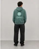 Canguro con capucha de color verde con efecto lavado, diseño de corte holgado, bolsillo frontal tipo canguro, cordones ajustables y logo estampado en el pecho.