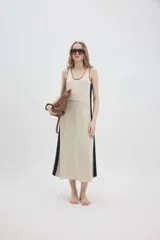 Vestido midi de punto en color beige con paneles laterales en contraste negros, escote redondo y tirantes anchos.