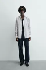 Camisa slim fit blanca de manga larga, cuello italiano y puños con botón. Cierre frontal de botonadura.