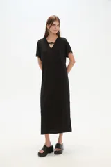 Vestido midi de corte holgado, color negro, con mangas cortas, cuello en V y detalle de cuentas decorativas en el escote.