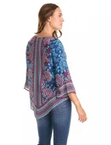 Blusa de gasa con estampado floral y geométrico en tonos azules, rojos y celestes. Presenta cuello a la base, mangas tres cuartos amplias y un corte asimétrico en el ruedo.