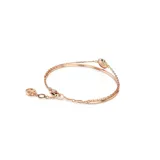 Pulsera de doble cadena fina color oro rosa con dije circular con cristales blancos incrustados.