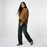 Blusa de color marrón con cuello camisero, cierre frontal de botones y mangas largas abullonadas con puños ajustados.