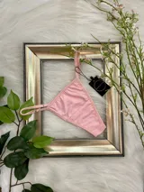 Pack de tres tangas de algodón con tiras laterales regulables. El conjunto incluye una prenda negra, una blanca y una color champagne.