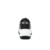 Sneaker de estilo chunky para mujer, con capellada de cuero negro y detalles en material metalizado plateado con textura. Cuenta con una suela de plataforma blanca de gran volumen y base de goma negra.