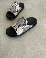 Sandalias chatas de cuero vacuno color beige con estampado de piel de serpiente.