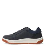 Championes urbanos Caterpillar modelo Apa Cush, color azul marino con suela blanca y base de goma color caramelo. Presentan cordones jaspeados y detalle de etiqueta pequeña en color amarillo.