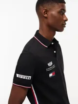 Chomba negra de algodón elástico con cuello polo, cartera de dos botones y mangas cortas. Presenta detalles de ribetes con diseño Global Stripe en el cuello y los puños, además de los logotipos de Tommy Hilfiger, TH x Cadillac Formula 1 Team, Pirelli y el número 11 en las mangas y el pecho.