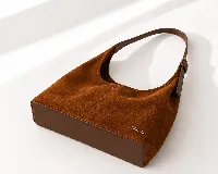 Cartera de gamuza marrón marca Chérie, de diseño clásico y amplio, con costuras visibles, una costura central vertical y asa ajustable.