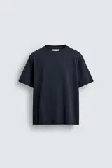 Camiseta de corte relajado confeccionada en algodón, con cuello redondo acabado en rib y manga corta.