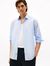 Camisa celeste de manga larga con logo de Tommy Hilfiger bordado en el pecho.