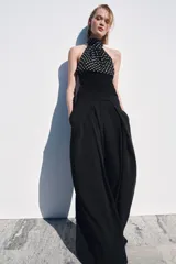 Top de cuello halter con hombros descubiertos, confeccionado con una combinación de tejidos. La parte superior presenta un estampado de lunares, mientras que la parte inferior es de tejido liso acanalado.