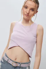 Musculosa corta negra sin mangas, de corte asimétrico frontal y ceñida al cuerpo.