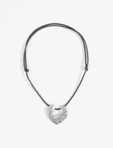 Collar con cordón negro ajustable y dije plateado con textura irregular.