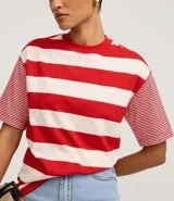 Remera de algodón con cuello redondo, cuerpo a rayas horizontales anchas rojas y blancas, y mangas cortas con rayas horizontales finas rojas y blancas. Presenta sisa desplazada y costuras aparentes.