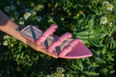 Sandalias bajas color rosa con tres tiras de cuero con nudos.