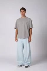 Remera de algodón gris con efecto acid wash, corte regular, mangas cortas y cuello redondo. Cuenta con un pequeño bordado tono sobre tono en el pecho y una etiqueta lateral distintiva de la marca en el ruedo.