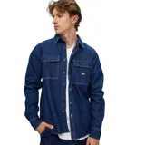 Camisa de denim azul con dos bolsillos frontales con botón y logo de la marca en uno de ellos.