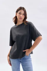 Remera de manga corta con efecto de lavado desgastado en color gris oscuro, de corte holgado y cuello redondo.
