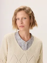 Buzo de lana color marrón topo, con cuello en V y diseño de punto calado en rombos en el frente y mangas.