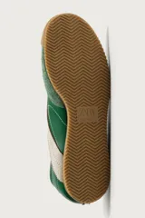 Zapatilla deportiva de estilo retro en color verde, confeccionada en una combinación de piezas de cuero y gamuza, con detalles a contraste en tono tostado y suela de goma dentada.