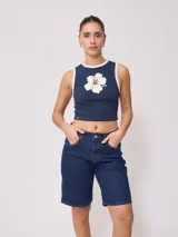 Musculosa ajustada color azul marino con cuello redondo y ribete blanco. Presenta un estampado frontal de una flor de hibisco blanca.