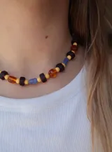 Collar corto de cuentas de cristal multicolores en tonos amarillos, naranjas, morados y celestes.