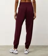 Pantalón deportivo tipo jogger color bordó, confeccionado en tejido de modal con poliéster y elastano. Presenta cintura fija, recortes estratégicos en el diseño y terminación ajustada en la botamanga.