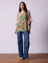 Blusa de gasa estampada con cuello a la base y lazo. Tiene plisado en la delantera, detalles de brillo en lurex, abertura central con botones y mangas 3/4 fluidas.