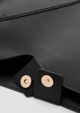 Bolso tipo hobo color negro, de diseño estructurado con costuras decorativas en forma de V invertida en el frente y una sola asa fija para llevar al hombro.