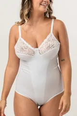 Body modelador blanco de alta contención, sin aro, con breteles elásticos regulables y broches en la entrepierna. Presenta encaje floral en la parte superior del busto y fundillo de algodón.