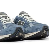 Championes urbanos New Balance modelo 2010, color azul con detalles en gris y blanco. Presentan una combinación de malla y gamuza en el exterior, con el logo N característico en los laterales y una entresuela robusta con tecnología de amortiguación.