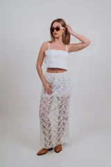 Falda larga blanca de encaje con diseño floral transparente y forro corto interior.