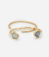 Brazalete rígido dorado con textura y resina celeste en los extremos.