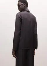 Blusa de tejido fluido con acabado satinado, corte recto, manga larga y cuello vuelto con diseño de pañuelo.