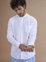 Camisa blanca de manga larga con cuello mao y cierre frontal de botones.