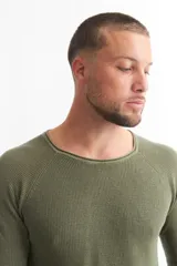 Sweater azul de punto con cuello redondo y mangas raglán.