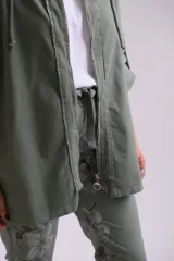 Campera verde militar con capucha, cierre frontal y mangas tres cuartos con detalle de ajuste.