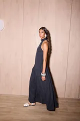 Vestido largo negro de crepe texturado con escote halter, cuello alto con volados y diseño holgado.