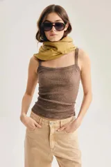 Musculosa de punto canalé color marrón, con breteles finos, escote recto y detalle de aplicación de tachas brillantes en toda la superficie. Diseño ajustado al cuerpo.