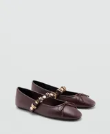 Zapato chatita de cuero sintético color marrón, con punta cuadrada, cordones decorativos en la capellada y una tira en el empeine adornada con tachas y argollas doradas.