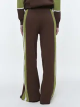 Pantalón de punto de pierna ancha, color negro con franjas laterales en tono azul. Presenta cintura elastizada y un diseño holgado que aporta comodidad.