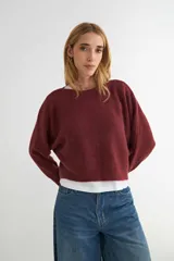 Sweater de punto negro, de corte holgado y diseño cropped, con cuello redondo y mangas largas.
