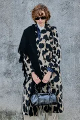 Tapado de corte recto y largo midi con estampado animal print de manchas grandes en tonos beige y negro. Presenta solapas clásicas, cierre frontal con botones y mangas largas.
