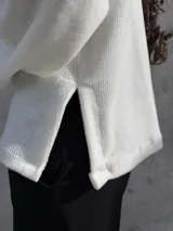 Polerón de cuello alto en color blanco, con diseño de calce holgado y mangas amplias. Confeccionado en tela suave y abrigada, ideal para un estilo urbano y relajado.