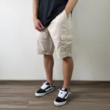 Bermuda cargo de gabardina color gris oscuro, con múltiples bolsillos laterales con solapa y cierre de botones.