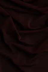 Top ajustado de manga larga, color borgoña oscuro, confeccionado en tejido elástico y semitransparente, con escote tipo cascada o drapeado.