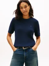 Cardigan de manga corta Tommy Hilfiger confeccionada en algodón orgánico, con cuello redondo y diseño de tejido acanalado. Presenta un pequeño logo bordado en el pecho.